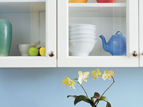 Kitchen_closeup_serene_blue_splashback_yellow_flower_white_cabinet_blue_teapot_green_vase